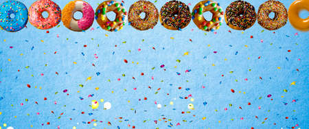 colorful donut with sprinkle on blue background. Background image with copy space