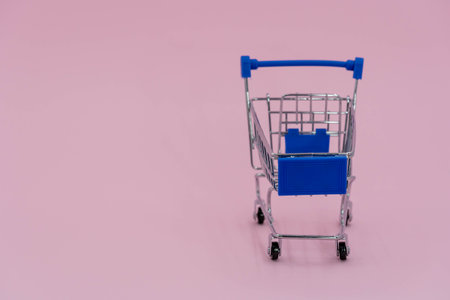 shopping cart isolated on pink background. Blue shopping cart online shopping conceptの写真素材