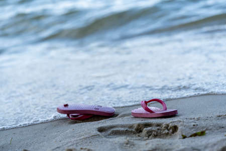 Red slippers on the beach. Thongs on the beachの写真素材
