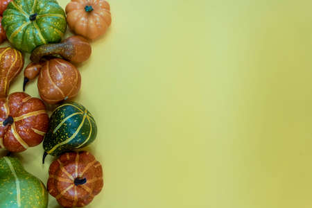 Autumn bottom border banner of pumpkins, gourds and fall decor on yellow background with copy spaceの写真素材