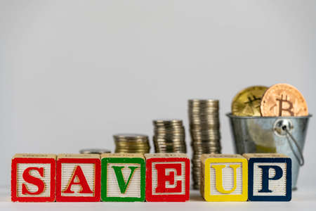 Money coins stack stair as step growing growth and wooden cube block with word SAVEUP. Investment and save money concept. save up on bitcoin. save up on cryptoの写真素材