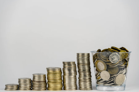 money saving, business financial growth, economy budget and investment concept. golden coins in jar and coin stack growth up on white background.の写真素材