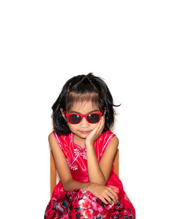 picture of beautiful liitle girl in red dress wearing sun glasses sitting on chair