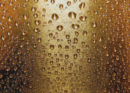  water drops on a golden yellow surface