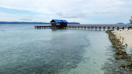 Two inviting dock house blue roofed near seashore with blue hills backgroundの写真素材