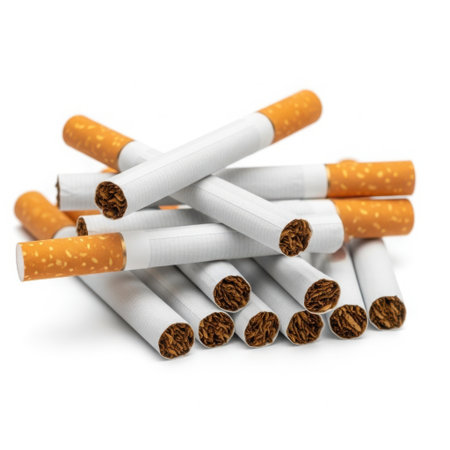 A close-up, high-angle shot of a pile of unlit cigarettes, featuring white paper and orange filter tips, against a white background.の素材