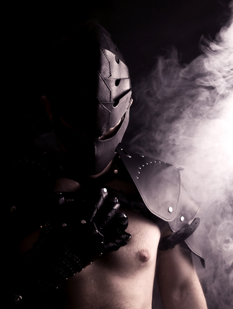 Warrior in mask in abstract smoke on black backgroundの写真素材