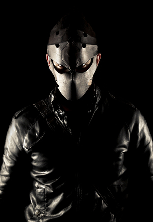 Warrior in mask, with sword on black background.の写真素材