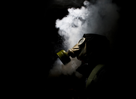 Portrait of man in gas mask on black background.
