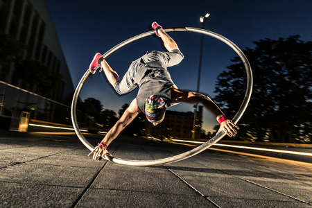 Cyr wheel performance session by young man at night.の写真素材