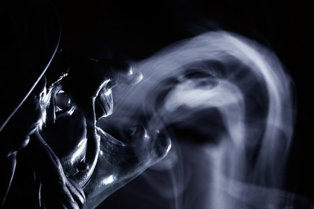 Red mask of devil in smoke on black background.の写真素材