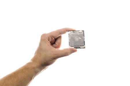 CPU with old thermal paste on IHS in mans hand isolated on white background.