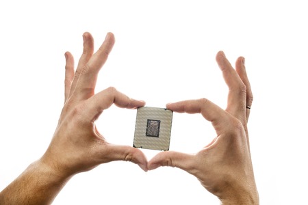 CPUs backside in mans hand isolated on white background.の写真素材