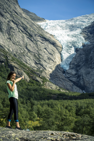 Portrait of woman standing in front of the Briksdaalsbreen glacier in Norway.の写真素材