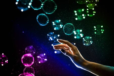 The transparent, iridescent soap bubbles isolated on black.