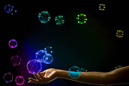 The transparent, iridescent soap bubbles isolated on black.の写真素材