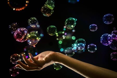 The transparent, iridescent soap bubbles isolated on black.の写真素材