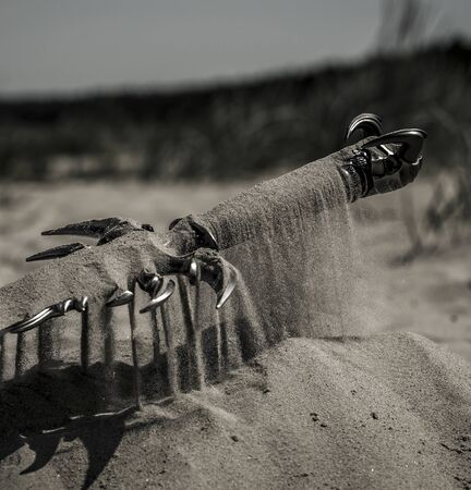 Accessories of a knight isolated on the sand during the day. Conceptual image. Sand is spreading.の写真素材