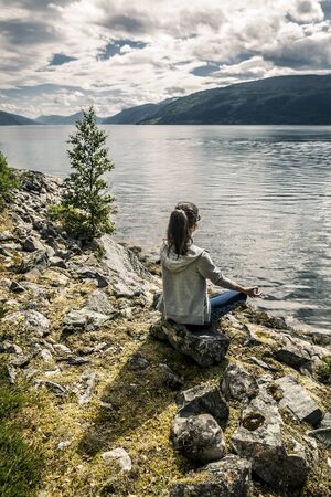 Young woman enjoying the sunny day on the fjord, Norwayの写真素材