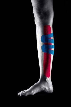 Medical taping for leg pain relief showed on young model.の写真素材