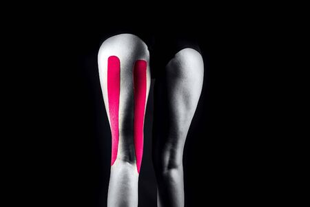 Medical taping for hamstrings pain relief showed on young model.の写真素材