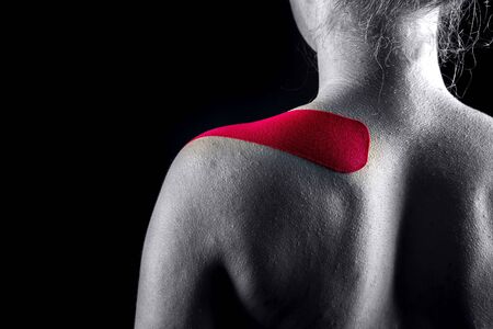 Medical taping for shoulder pain relief showed on young model.の写真素材