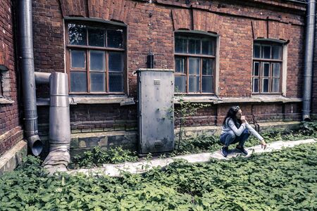 Portrait of young woman walking around the old factory.