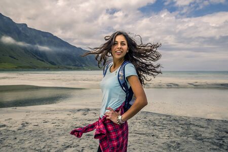 Young woman is walking on the beach of Norway