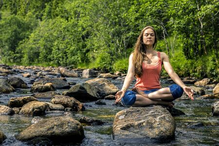 Young woman sitting on the stone, Norwayの写真素材
