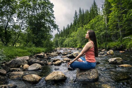Young woman sitting on the stone, Norwayの写真素材