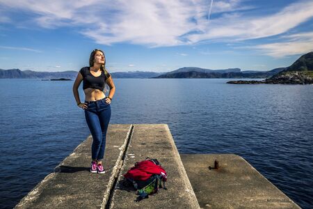 Young woman is standing on the stone, Norwayの写真素材