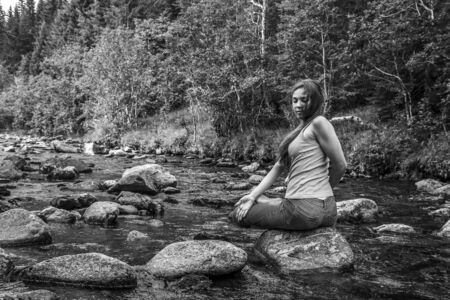 Young woman sitting on the stone, Norwayの写真素材