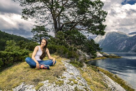 Young and sporty woman posing on the rocks, Norwayの写真素材