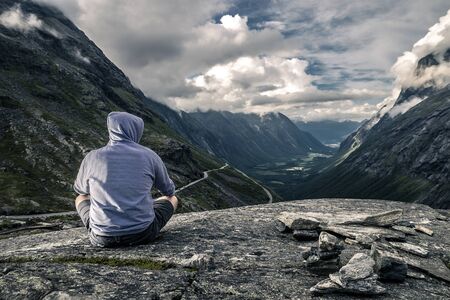 Young man is hiking in Trollstigen, Norwayの写真素材