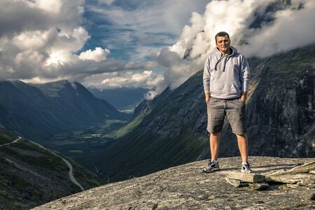 Young man is hiking in Trollstigen, Norwayの写真素材
