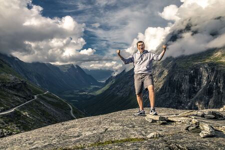 Young man is hiking in Trollstigen, Norwayの写真素材