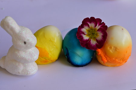 Easter bunny and colored eggs on a white background, close-upの写真素材