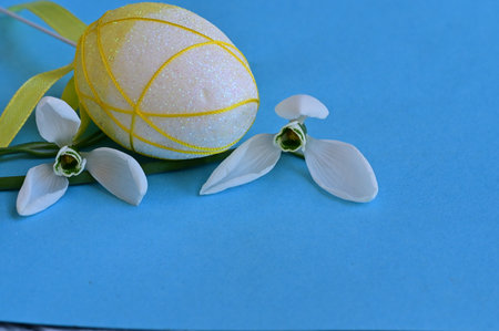 Easter egg with snowdrops on a blue background with copy spaceの写真素材