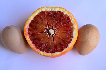 Bloody oranges and eggs on a white background, close-upの写真素材