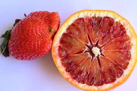 Red orange and strawberry on a white background, close-up.の写真素材
