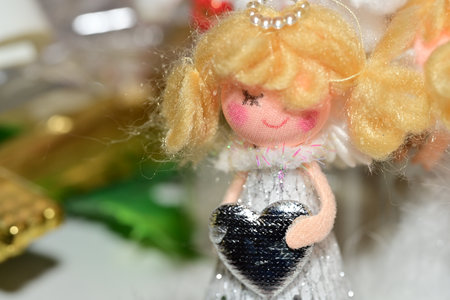 handmade crochet doll with a heart on the background of Christmas giftsの写真素材