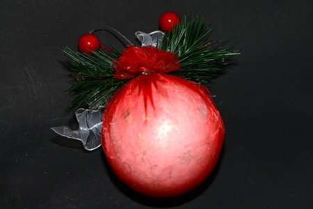 Christmas decoration on a black background. Red ball with a red ribbon.の写真素材