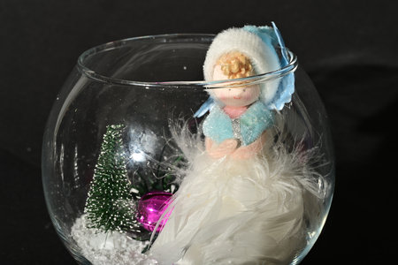 Christmas angel in a glass vase on a black background. Christmas decoration.の写真素材