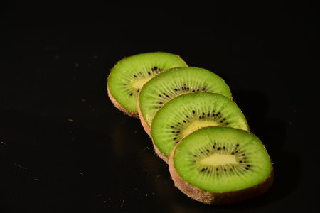Kiwi fruit slices isolated on black background. Healthy food.の写真素材