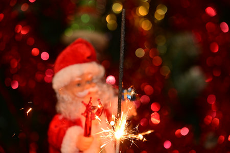 santa claus with sparklers on a red bokeh backgroundの写真素材