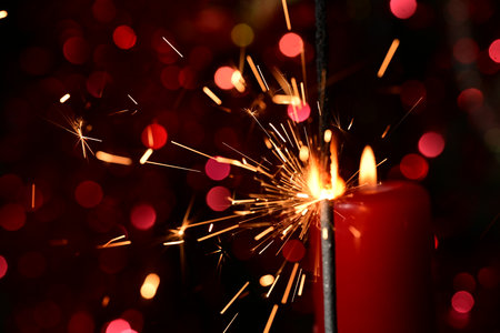 Burning candle with sparks on a dark background, close-upの写真素材