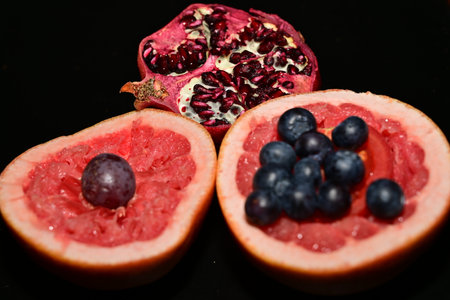grapefruit and pomegranate on a black background, fruitの写真素材
