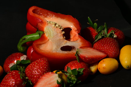 Strawberry and pepper on black background. Healthy food concept.