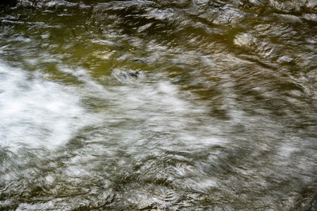 abstract background of water flowing over rocks in a river or stream