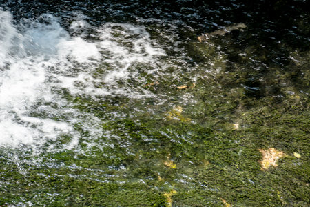 Close up of water flowing over rocks in a river. Abstract background